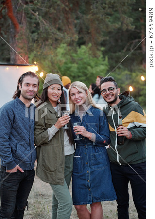 Group of young affectionate men and women with drinks celebrating life occasion 67359489