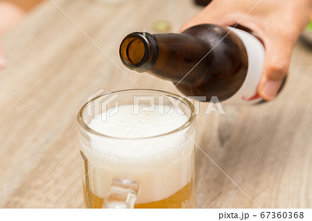 瓶ビールをビールジョッキへ注ぐ手元 瓶ビールをビールジョッキへ注ぐ手元 67360368