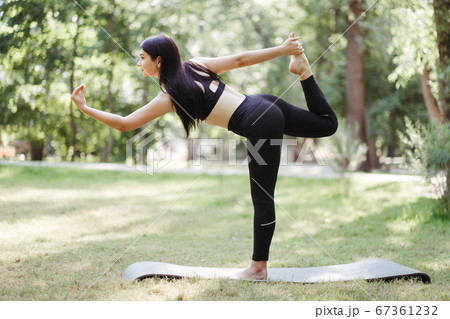 Young fit woman doing morning yoga in the park Young fit woman doing morning yoga in the park 67361232