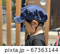 庭でうつむき加減で立っている男の子の横顔 67363144