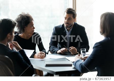 Focused mixed race employees listening to team leader. Focused mixed race employees listening to team leader. 67363957
