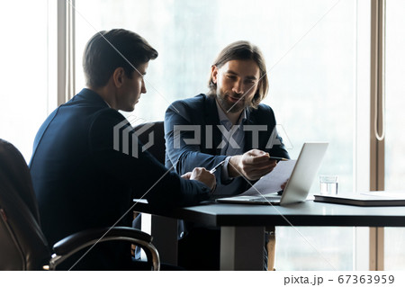 Smiling employees analyzing statistics data at meeting. Smiling employees analyzing statistics data at meeting. 67363959