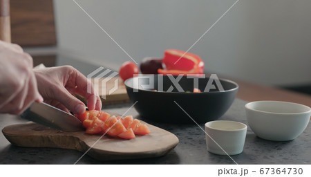 man chop tomatoes on olive wood board 67364730