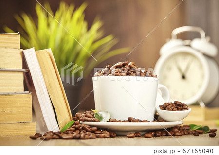 Coffee cup with beans, stack books, white alarm 67365040