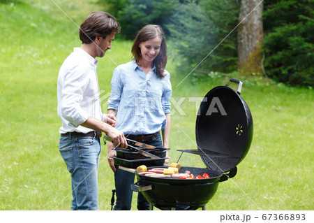 Couple cooking food on barbecue 67366893
