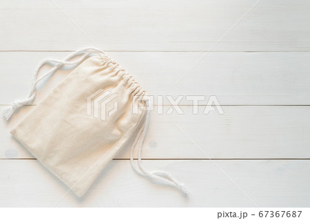 Canvas bag with drawstring, mockup of small eco sack made from natural cotton fabric cloth flat lay on white wood background from top view 67367687