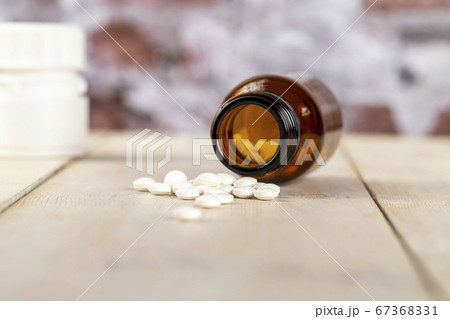 Home medicine.Glass bottles of medicine and roubd white pills 67368331