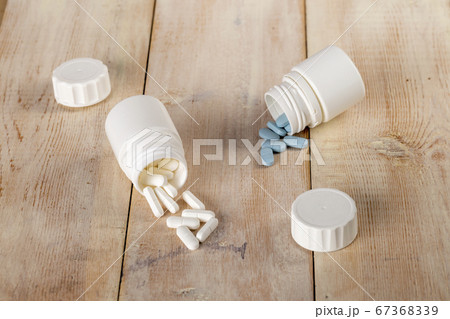 Home medicine.White plastic pill bottles and different pills Home medicine.White plastic pill bottles and different pills 67368339