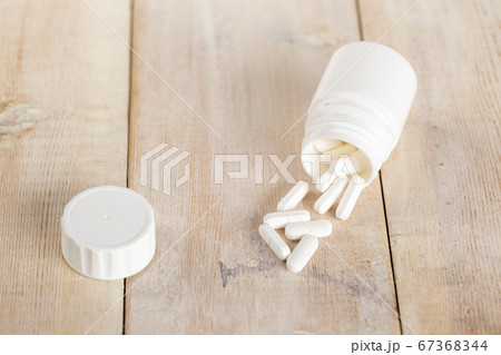Home medicine.White plastic pill bottles and different pills Home medicine.White plastic pill bottles and different pills 67368344