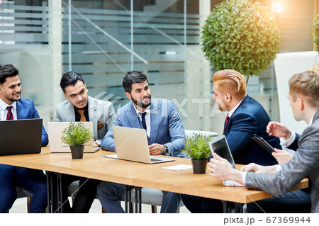 Young negotiators speaking at multi-ethnic office meeting Young negotiators speaking at multi-ethnic office meeting 67369944