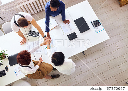 Multiethnic colleagues in formalwear joining hands together Multiethnic colleagues in formalwear joining hands together 67370047
