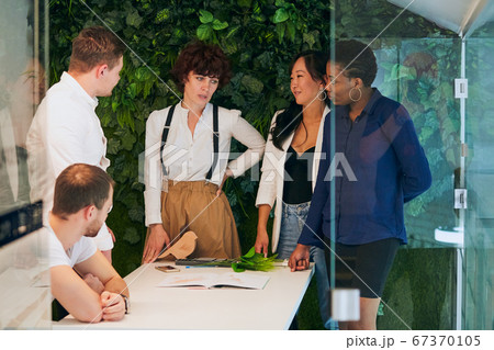 Diverse multiethnic group of young colleagues gathered together in office 67370105