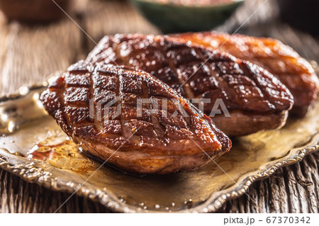 Crispy grilled duck breasts resting on a vintage Crispy grilled duck breasts resting on a vintage 67370342
