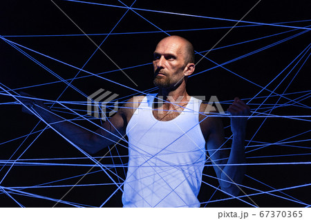Image of adult man tangled in threads in neon light Image of adult man tangled in threads in neon light 67370365