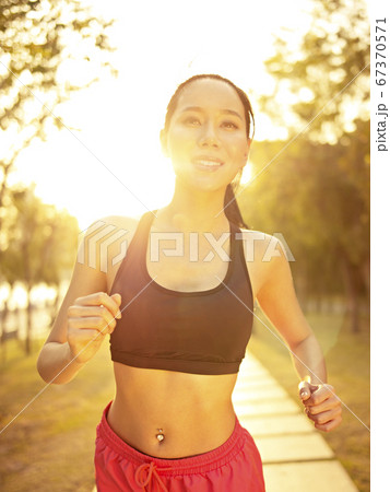 young asian woman running outdoors in park at sunset young asian woman running outdoors in park at sunset 67370571