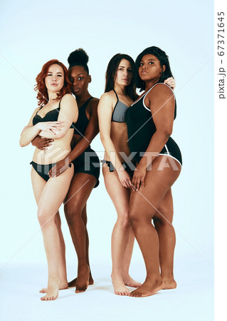 Two female interracial homosexual couple standing in sports underwear isolated Two female interracial homosexual couple standing in sports underwear isolated 67371645