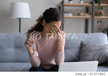 Tired young woman rub eyes suffering from migraine 67371802