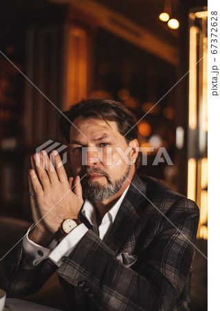 Bearded businessman thinks about important while sitting in leather armchair. Bearded businessman thinks about important while sitting in leather armchair. 67372628