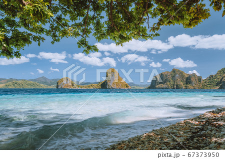 Palawan well known places. Palm trees and lonely island hopping tour boat on empty Ipil beach of tropical Pinagbuyutan, Philippines 67373950
