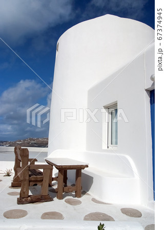 Table and bench in yard of Mykonos, Greece. House 67374945