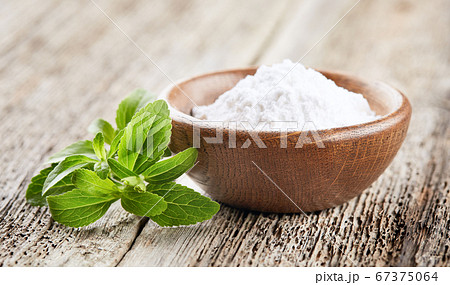Stevia plant with powder on wooden background 67375064