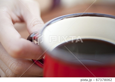 コーヒーカップを持つ女性の手元 67378062