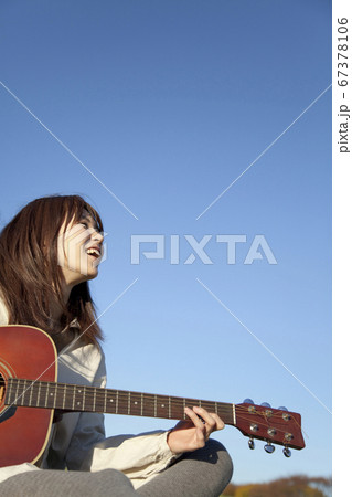 ギターを弾く女性 67378106