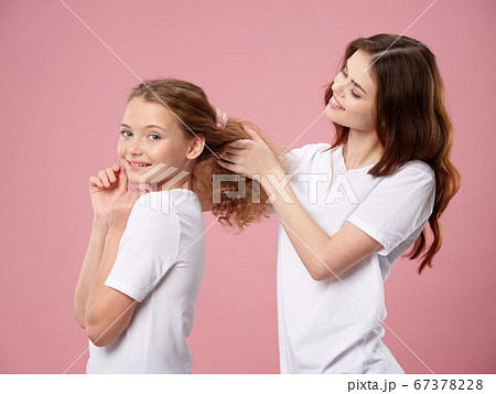 Happy woman does a hairdress to a little daughter  67378228