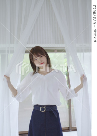 カーテンを開く若い女性 カーテンを開く若い女性 67379612