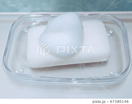 浴室に置かれた透明なソープディッシュにのった泡付きの石けん 67380146