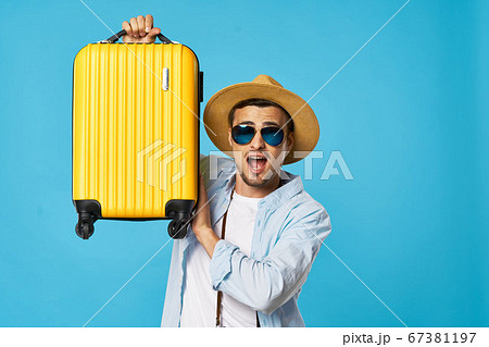 man on a blue background with glasses and a yellow suitcase  67381197