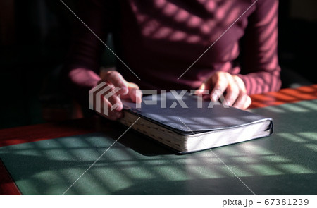 Woman's hands on holy bible. Focus on the book. 67381239