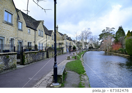 ボートン・オン・ザ・ウォーター、川面と「石造りの家」の街並み 67382476