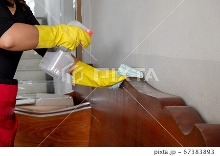 The happy housewives in rubber gloves wipe the dust with a spray while cleaning the tables and chairs cleaning concept The happy housewives in rubber gloves wipe the dust with a spray while cleaning the tables and chairs cleaning concept 67383893