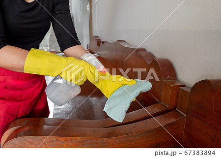 The happy housewives in rubber gloves wipe the dust with a spray while cleaning the tables and chairs cleaning concept The happy housewives in rubber gloves wipe the dust with a spray while cleaning the tables and chairs cleaning concept 67383894