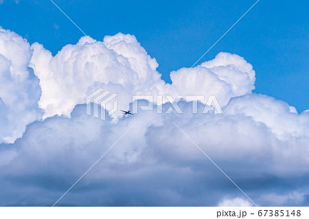 入道雲と航空機 夏の空模様の写真素材
