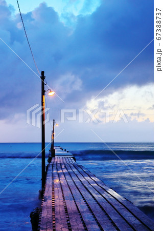 夕暮れ立ち込める桟橋のある海水浴場 67388737