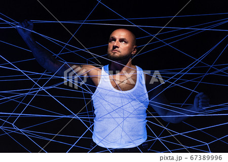 Man tangled in white threads with hands up Man tangled in white threads with hands up 67389996