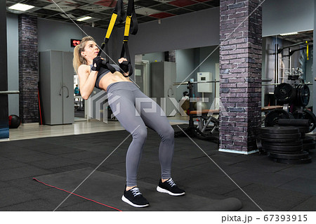 Crossfit fitness TRX training exercises at gym woman push-up workout Crossfit fitness TRX training exercises at gym woman push-up workout 67393915