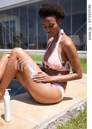Woman applying sunscreen on her legs Woman applying sunscreen on her legs 67394586
