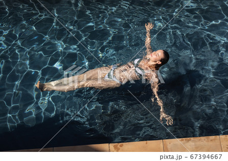 Woman swimming in the pool 67394667