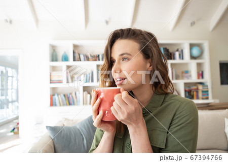 Woman holding coffee cup at home Woman holding coffee cup at home 67394766