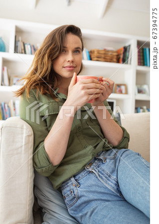 Woman holding coffee cup at home 67394775