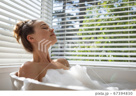 Woman relaxing in a bathtub 67394830