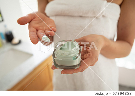 Mid section of woman using face pack 67394858