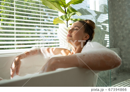 Woman relaxing in a bathtub 67394866