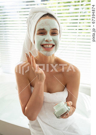 Portrait of woman applying face pack in bathroom 67394874