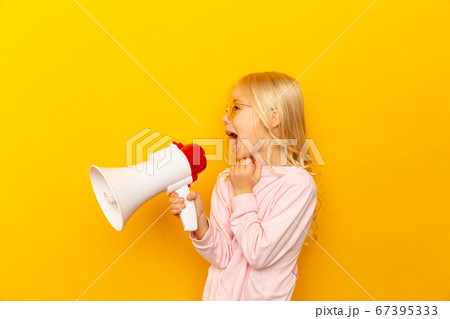 Kid shouting through megaphone. Communication concept. yellow background as copy space for your text Kid shouting through megaphone. Communication concept. yellow background as copy space for your text 67395333