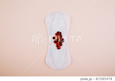 Menstrual pads with bright red glitter on pink background. Woman periods cycle, menstruation frequency. Minimalist still life photography concept Menstrual pads with bright red glitter on pink background. Woman periods cycle, menstruation frequency. Minimalist still life photography concept 67395479