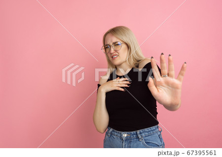 Portrait of young caucasian woman with bright emotions on coral pink studio background Portrait of young caucasian woman with bright emotions on coral pink studio background 67395561